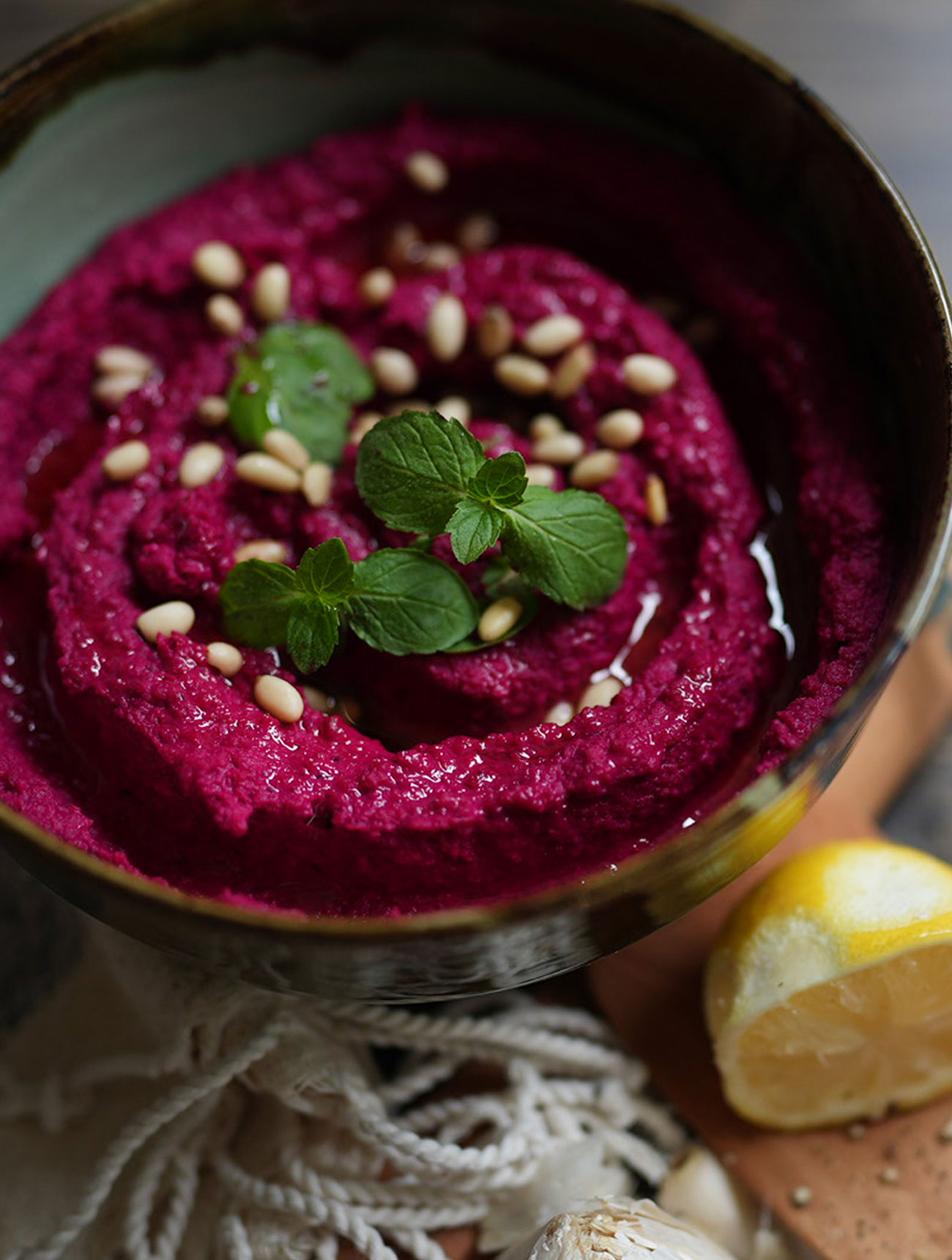 A creamy, bright creamy bowl of Easy Beet Hummus garnished with sesame seeds and parsley