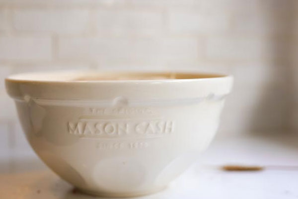 A Mason Cash mixing bowl filled with sourdough ingredients, resting for 30 minutes before the first stretch and fold.