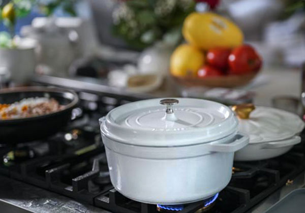 Classic chicken pot pie cozy creamy comfort food behind the scenes look at classic chicken pot pie vegetables simmering in a white staub dutch oven A cozy kitchen moment with colorful veggies prepped in the background Sourdough afterglow A white Staub Dutch oven on a stovetop with chicken pot pie vegetables cooking inside. A vegetable bowl sits in the background on a cozy kitchen counter.