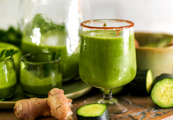 Green detox goblet round tray root ingredients wellness shot a round tray holds a single elegant goblet filled with vibrant green detox drink flanked by two smaller glasses to the left Fresh root ingredientslike ginger and turmericrest in front grounding the composition with warmth and earthy wellness This inviting setup is perfect for showcasing healing tonics natural ingredients and moments of mindful nourishment Sourdough afterglow Glass of Green Apple Power Juice with fresh apple slices and ginger on a wooden tray