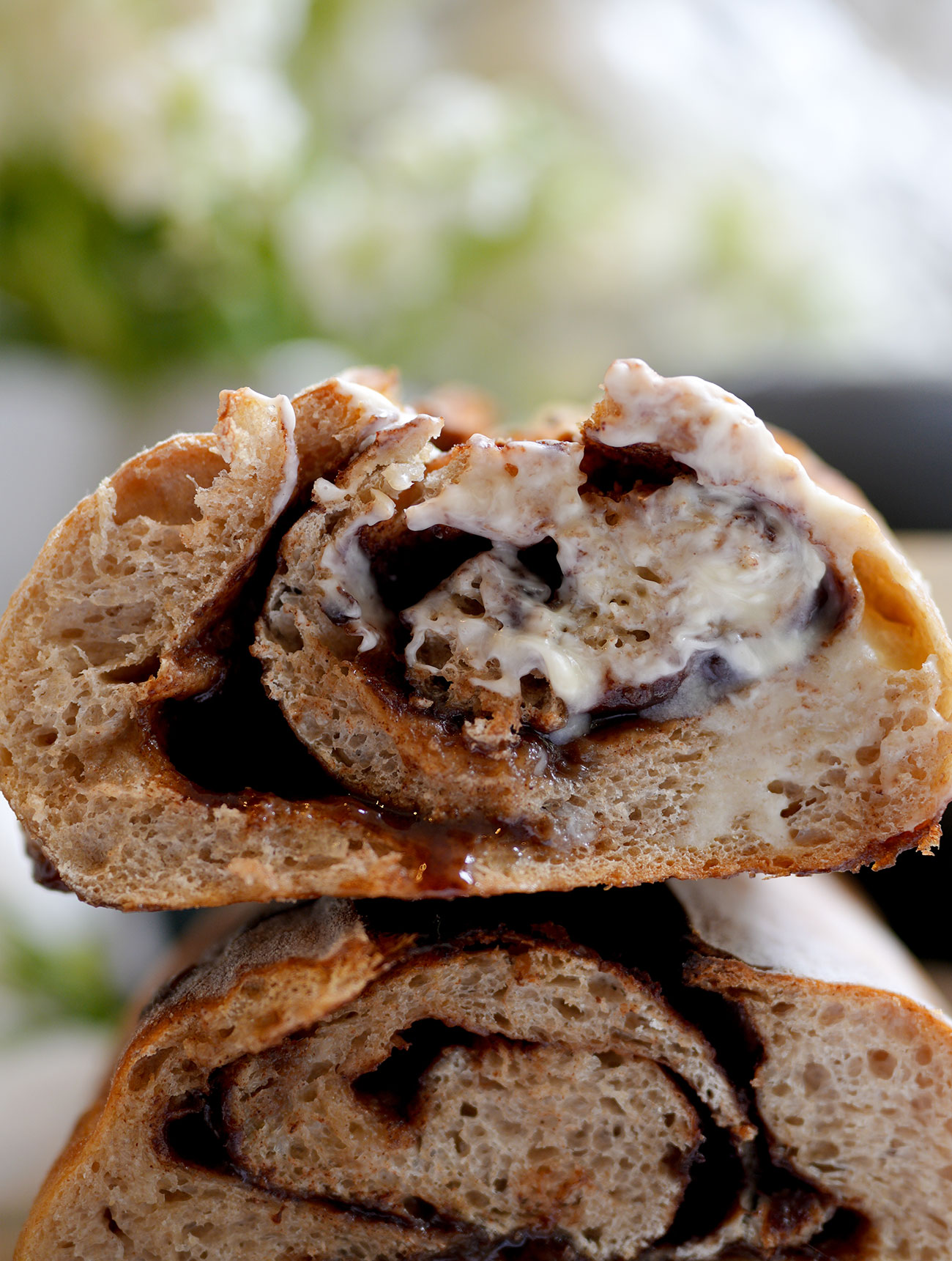Sliced cinnamon swirl sourdough bread with butter spread on the edge, showing off the crumb and cinnamon sugar swirl