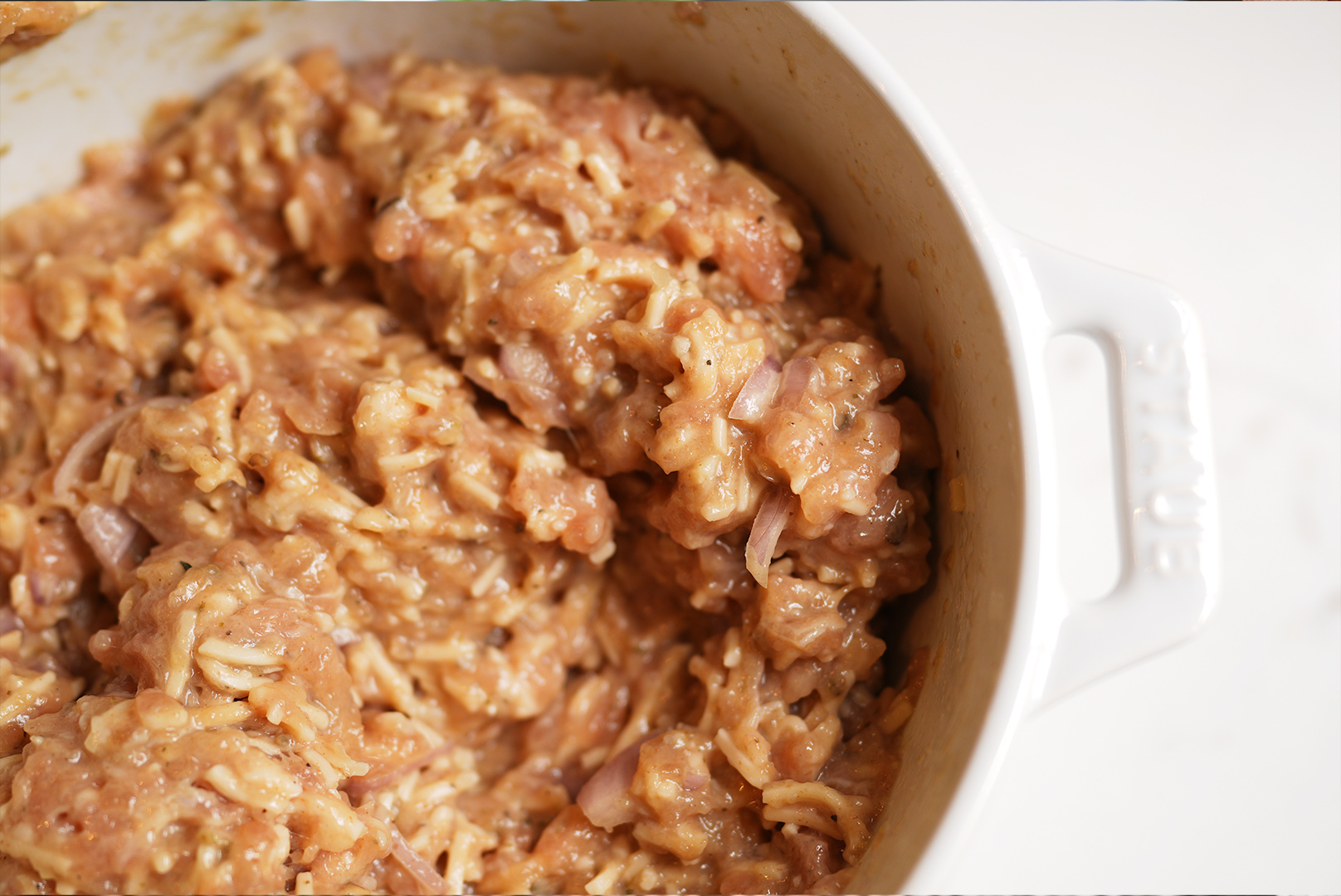 Oven baked sourdough discard chicken meatballs freshly ground chicken in a rustic bowl used as the lean protein base for sourdough discard chicken meatballs Essential for creating juicy tender oven baked meatballs Sourdough afterglow Fresh ground chicken in a bowl ready to be mixed for sourdough discard chicken meatballs