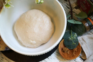 Overhead view of sourdough dough in a bowl at the start of bulk fermentation with small bubbles forming on the surface