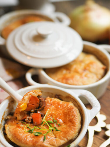 sourdough beef pot pies baked in white cocottes, set on a wooden board with flaky sourdough crust and golden filling—cozy, rustic, and ready to serve.