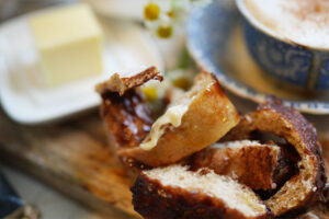 Afterglow swirls cinnamon sourdough bread with brown sugar s a soft slice of cinnamon swirl sourdough bread torn gently apart with one edge smothered in creamy butter In the background a warm latte and butter dish complete this cozy just one more bite scene Sourdough afterglow Torn slice of cinnamon swirl sourdough bread with one edge smothered in butter, a latte and butter dish in the background
