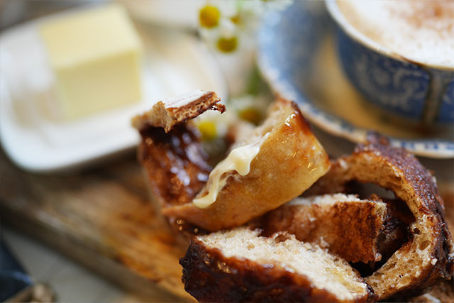 Afterglow swirls cinnamon sourdough bread with brown sugar s a soft slice of cinnamon swirl sourdough bread torn gently apart with one edge smothered in creamy butter in the background a warm latte and butter dish complete this cozy just one more bite scene sourdough afterglow Torn slice of cinnamon swirl sourdough bread with one edge smothered in butter, a latte and butter dish in the background
