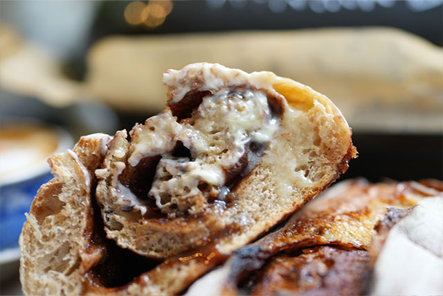 Afterglow swirls cinnamon sourdough bread with brown sugar s a close up view of cinnamon swirl sourdough bread sliced and ready to enjoy the top of the slice is generously smothered in butter highlighting the rich swirl and golden crumb of this cinnamon roll inspired loaf sourdough afterglow Close-up of a sliced cinnamon swirl sourdough loaf with the top portion smothered in butter, ready to eat