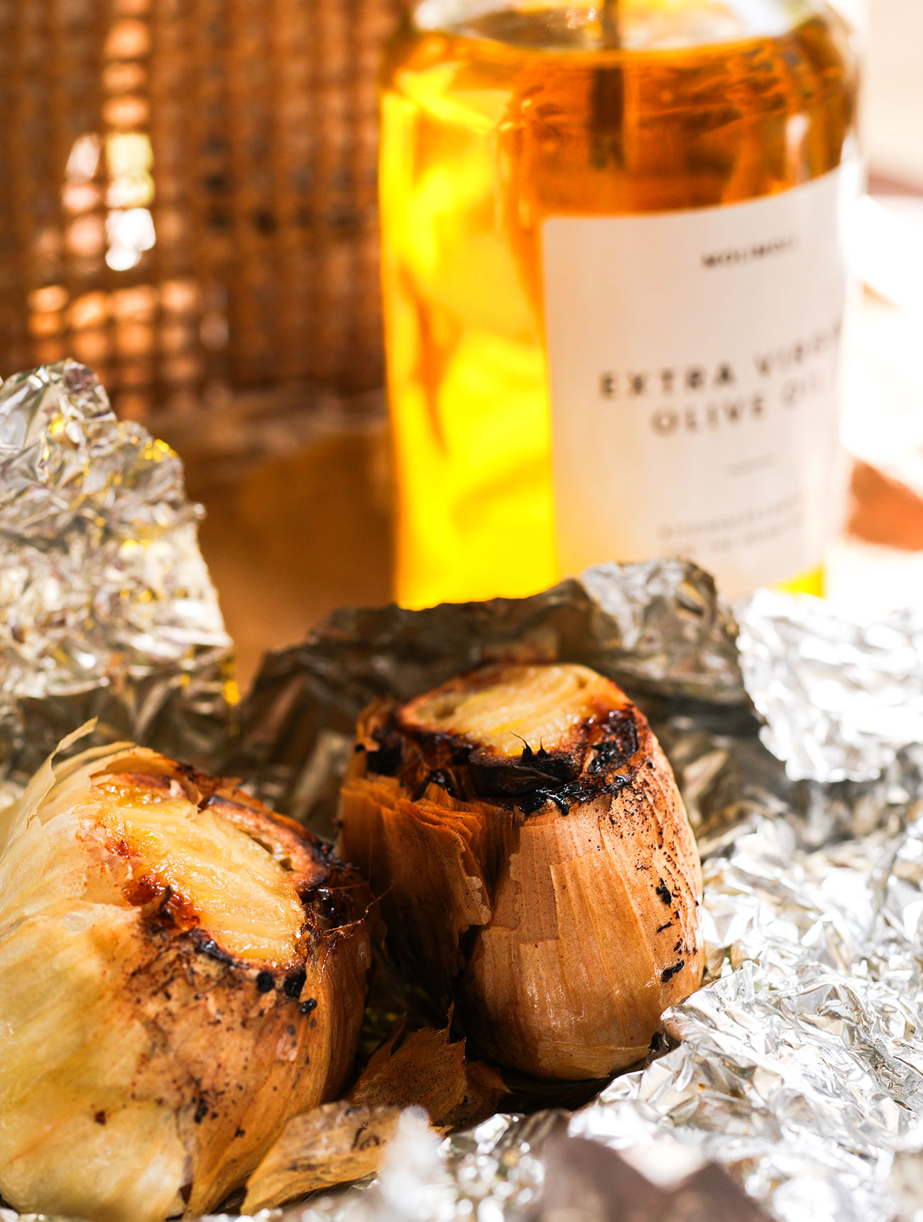 Roasted garlic in foil with olive oil in the background, ready to be used in sourdough bread