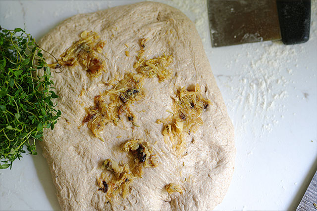 Three flour roasted garlic herb sourdough bread mashed roasted garlic is spread across sourdough dough during shaping with fresh herbs nearbyready to be folded in for a deeply flavorful inclusion Sourdough afterglow Roasted garlic spread on sourdough dough with fresh herbs to the left, ready for folding