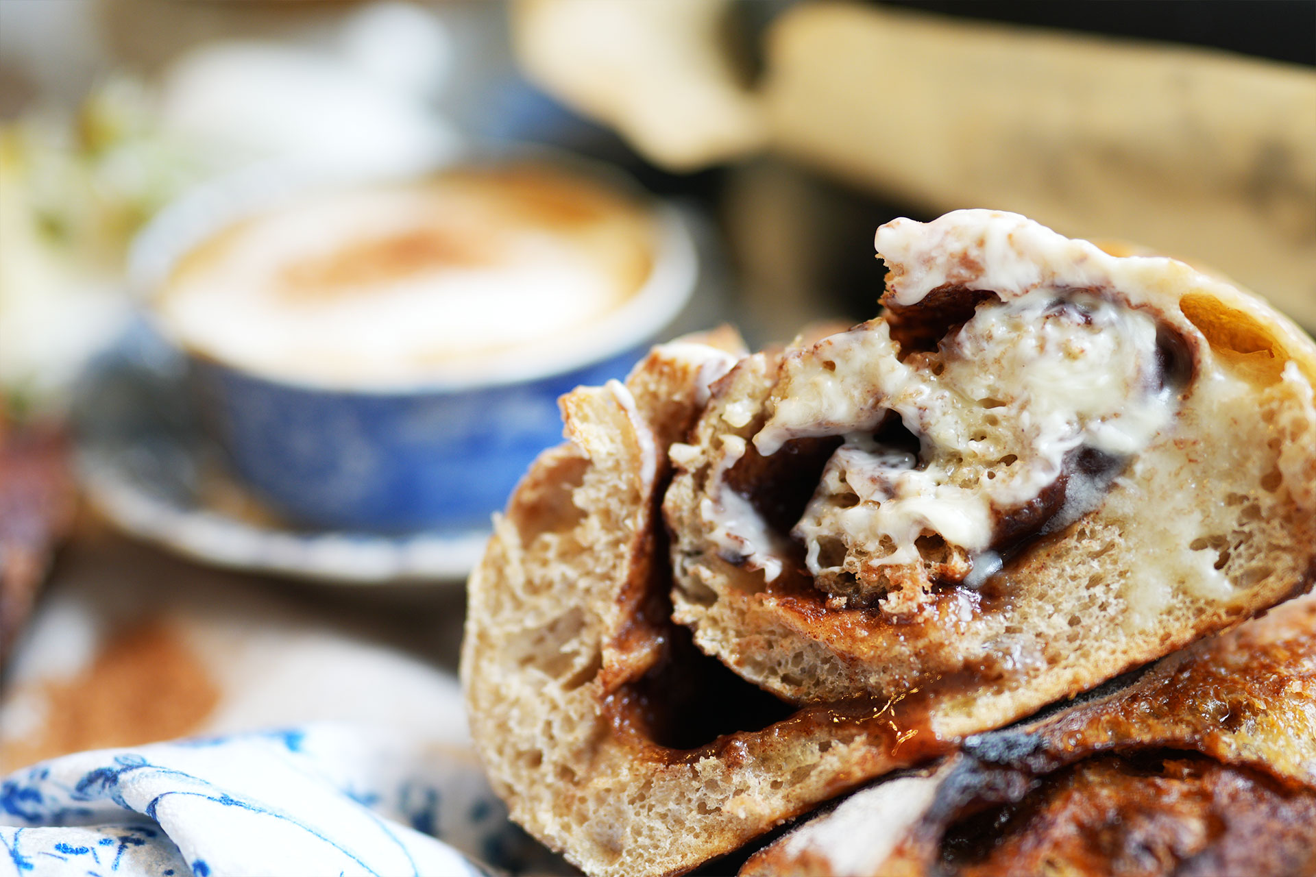 Afterglow swirls cinnamon sourdough bread with brown sugar s sliced cinnamon swirl sourdough bread with one edge buttered a latte in the background and soft flowers adding a cozy delicate touch sourdough afterglow Sliced cinnamon swirl sourdough bread with one edge buttered, a latte in the background, and soft flowers adding a cozy, delicate touch