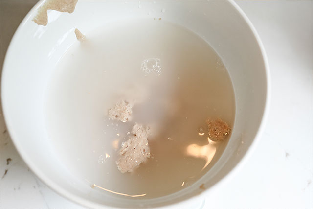 Three flour roasted garlic herb sourdough bread a top down view of sourdough starter and water whisked together in a bowlan essential first step that sets the stage for a soft beautifully risen loaf Sourdough afterglow Sourdough starter mixed with water in a bowl, ready for flour