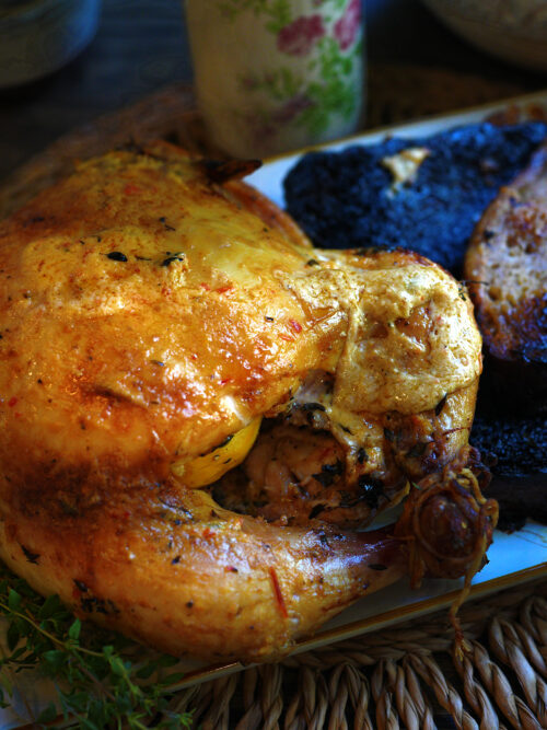 Whole roasted chicken on charred sourdough slices with creamy harissa crème fraîche glaze