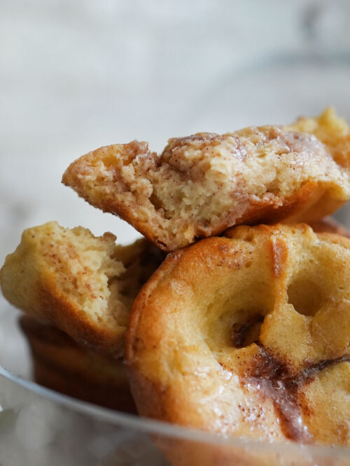Glass dish filled with golden sourdough popovers, served with a spoonful of whipped honey cinnamon butter.